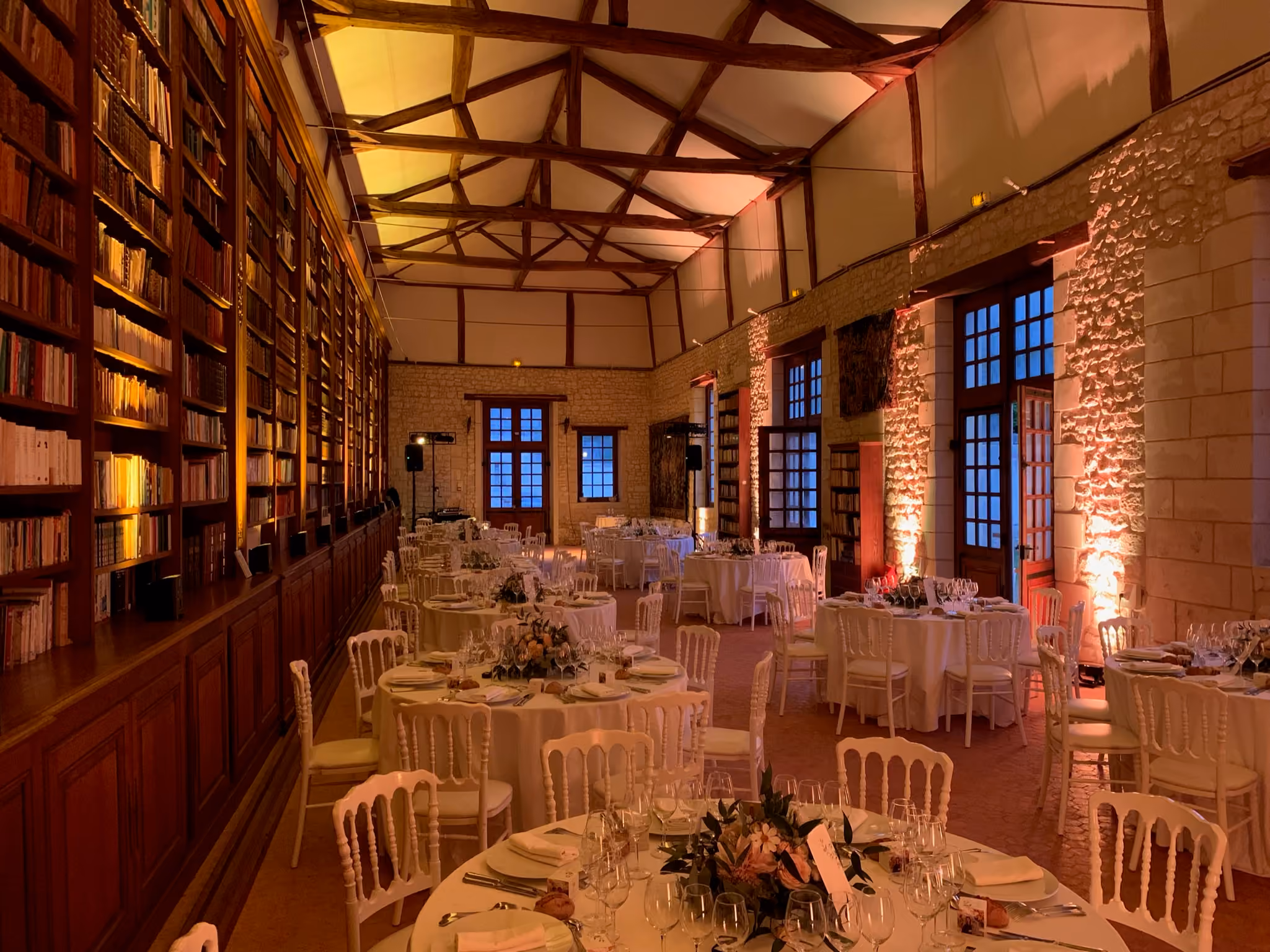 Enfilade de la bibliothèque du château dressée pour un banquet, rayonnages sur toute la hauteur