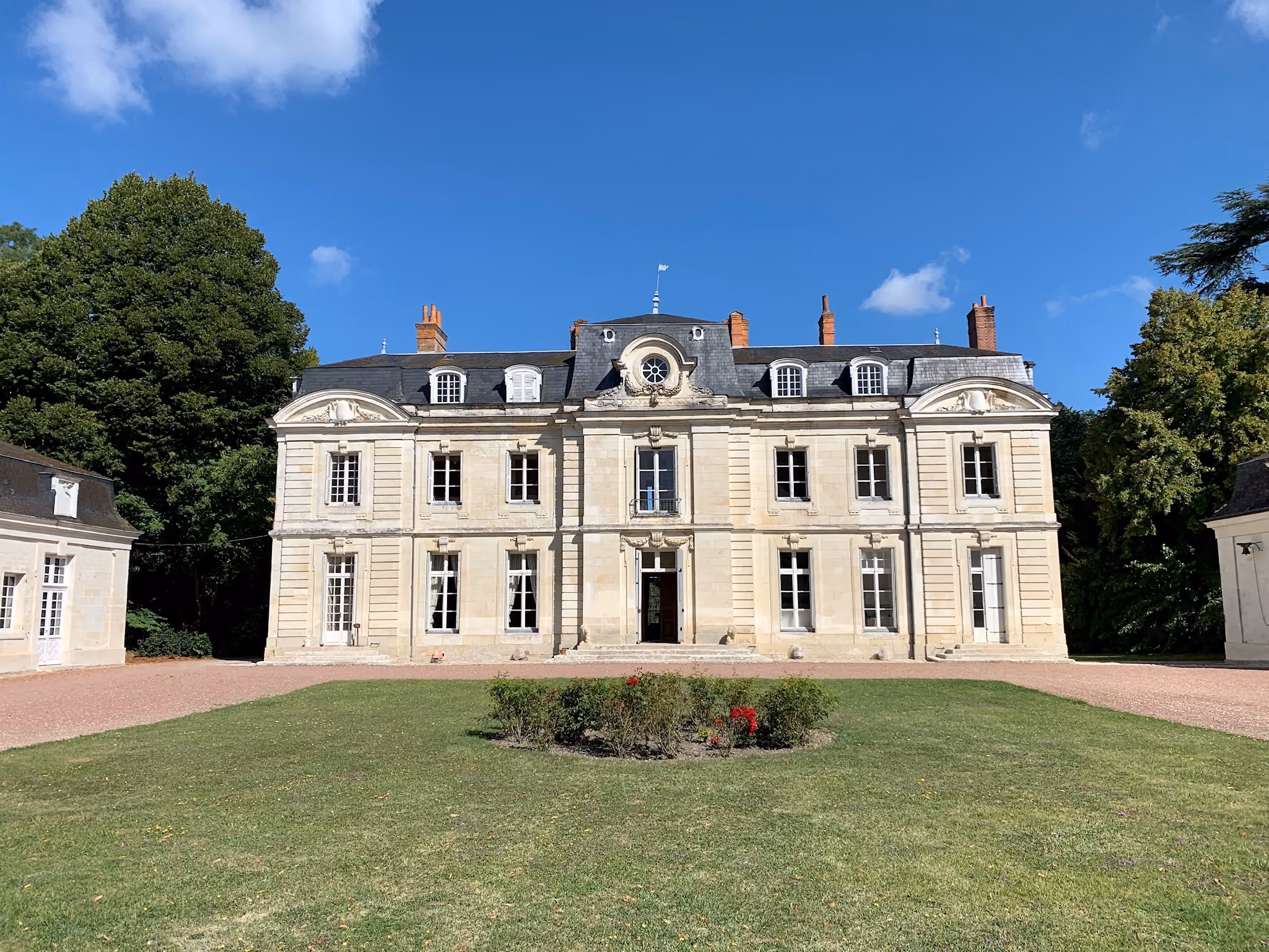 Façade en pierre de taille du château XVIIIe vue de face depuis la pelouse d'honneur