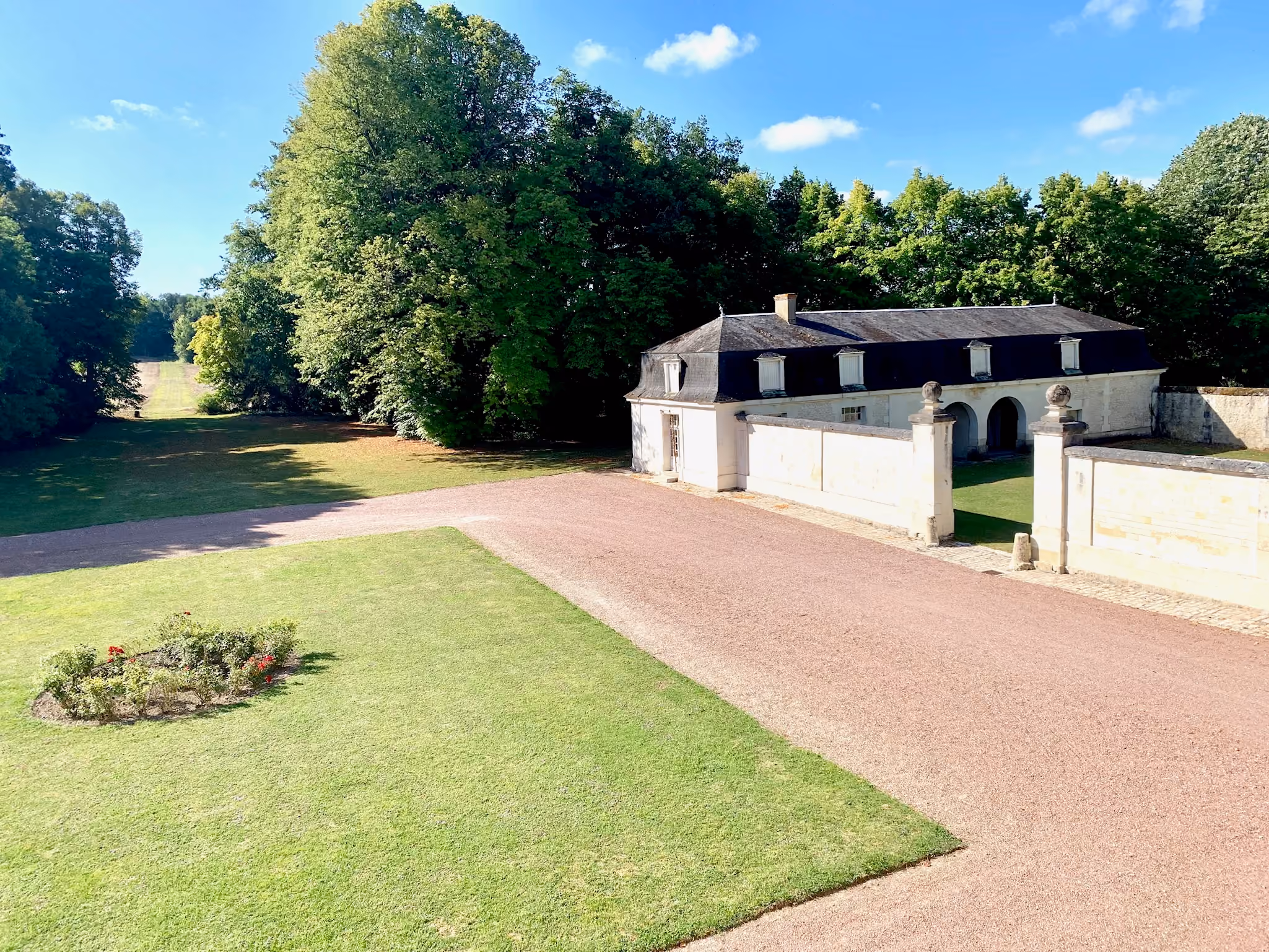 Cour d'honneur sablée, communs à porche cintré et perspective du parc vus d'en haut